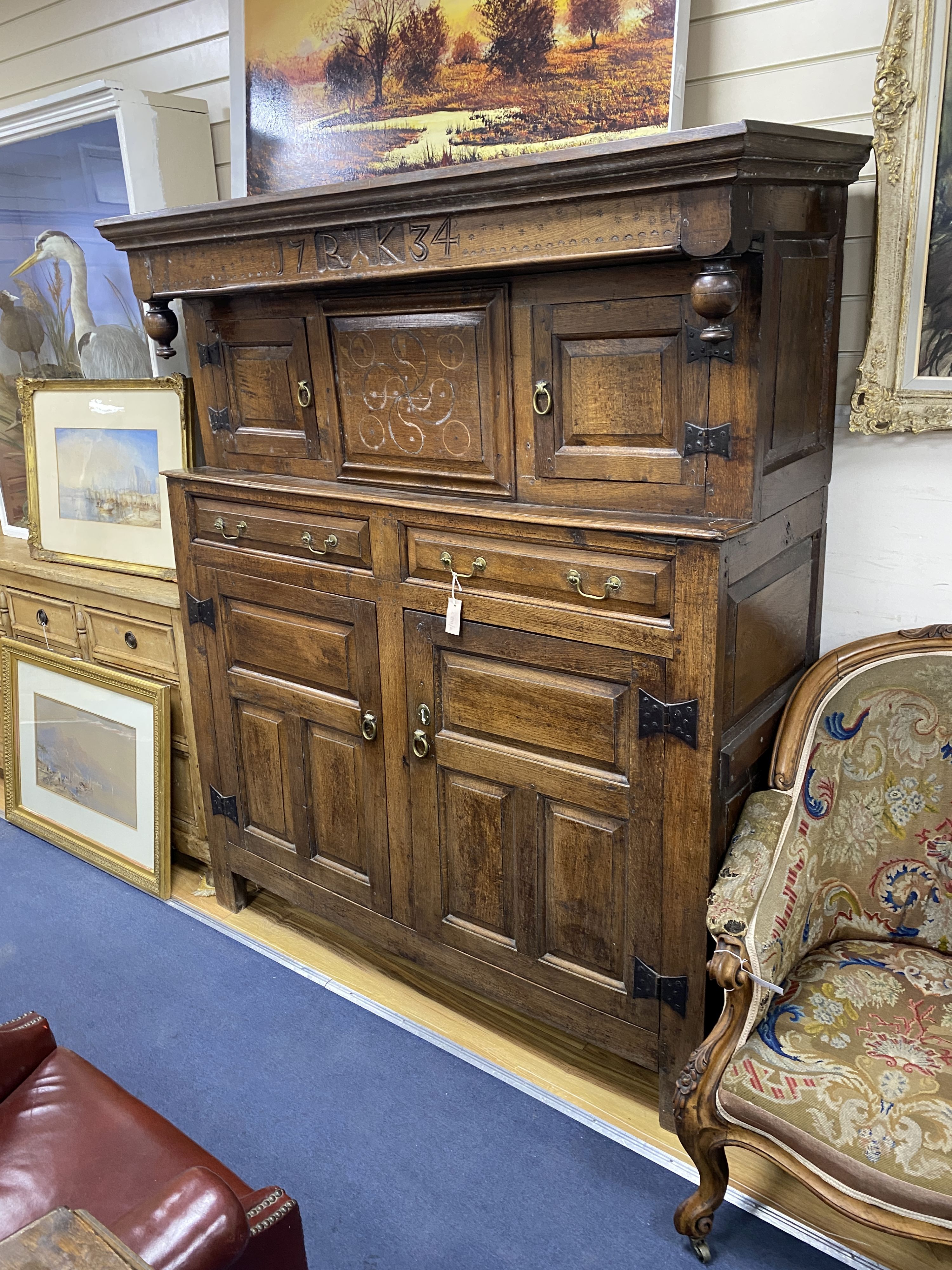 An 18th century oak court cupboard dated 1734, length 145cm, depth 55cm, height 176cm